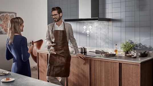 Man and woman in kitchen with illustration by the hood